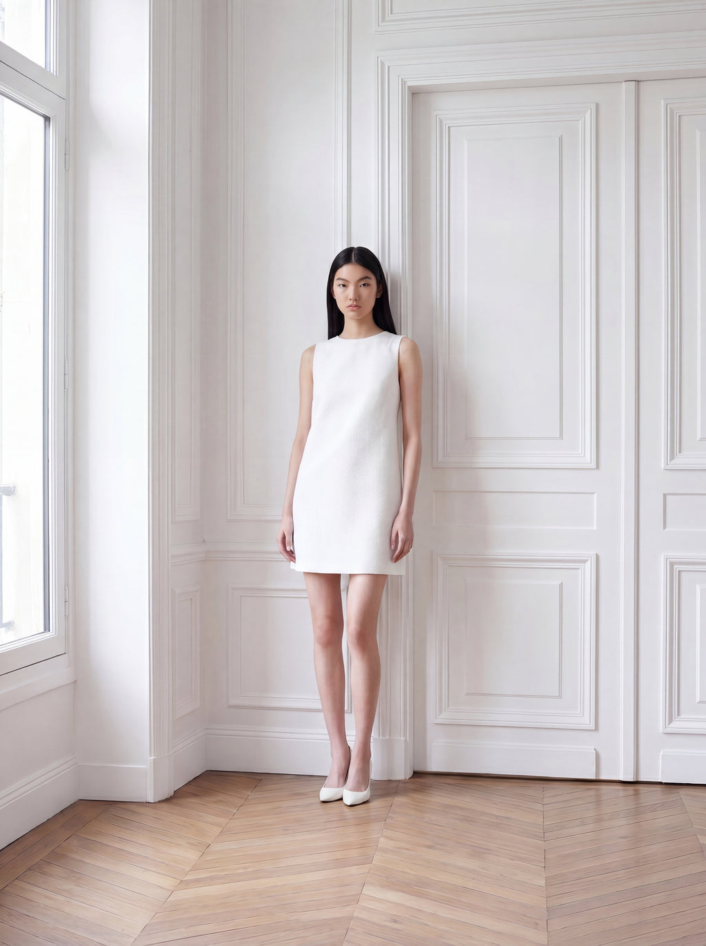 Model trägt weißes Jacquardkleid mit gerader, eleganter Silhouette
