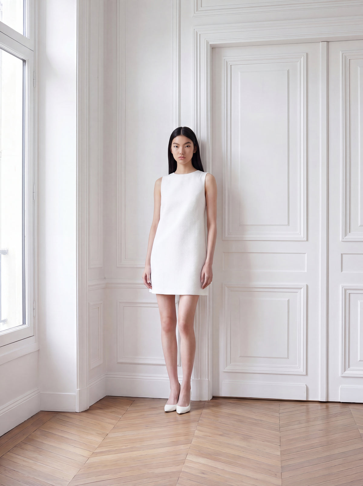 Model trägt weißes Jacquardkleid mit gerader, eleganter Silhouette