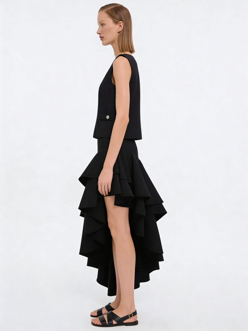 Model trägt schwarzen Wollrock mit hoher Taille und asymmetrischem Volantsaum