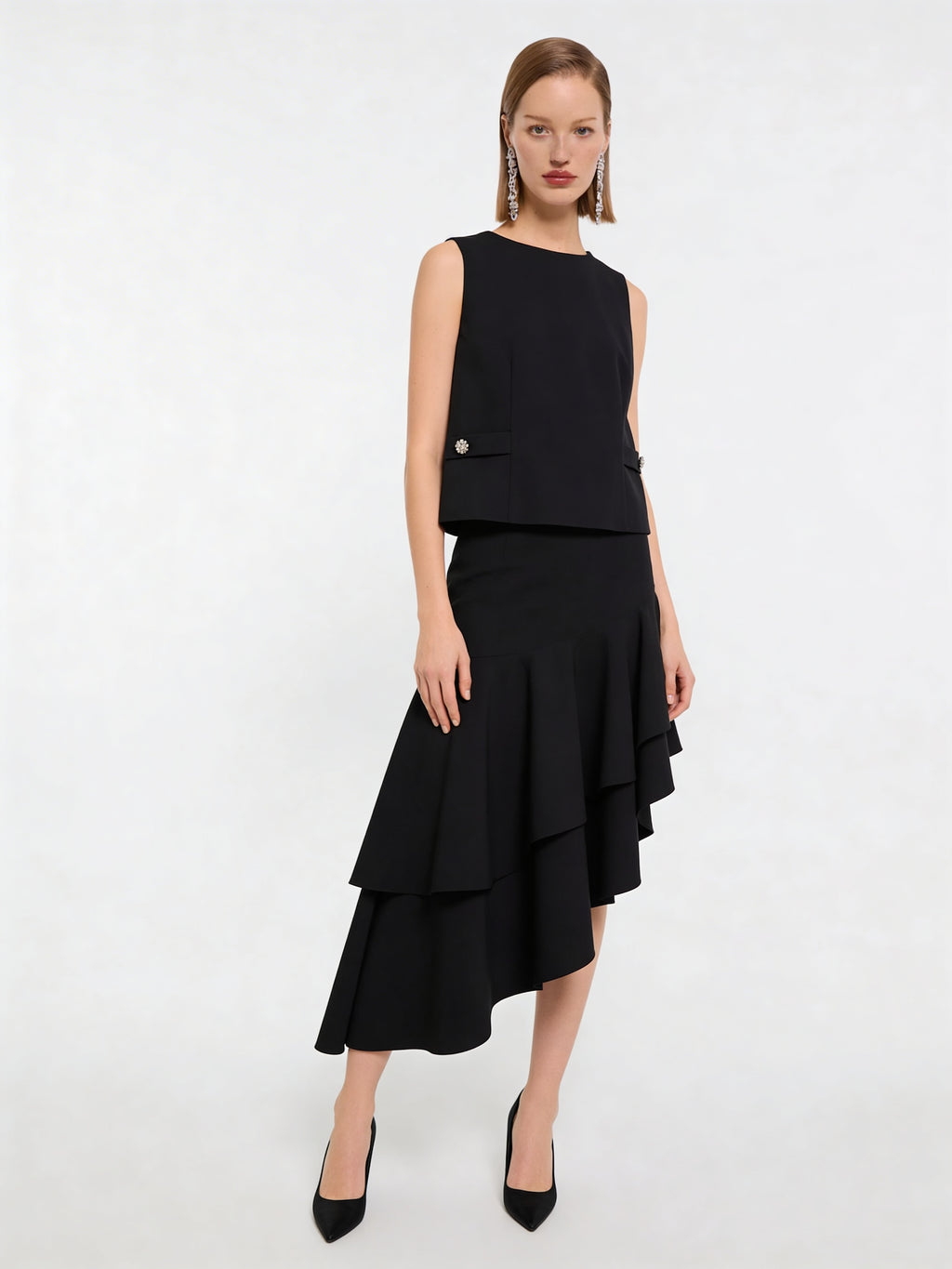 Model trägt schwarzen Wollrock mit hoher Taille und asymmetrischem Volantsaum