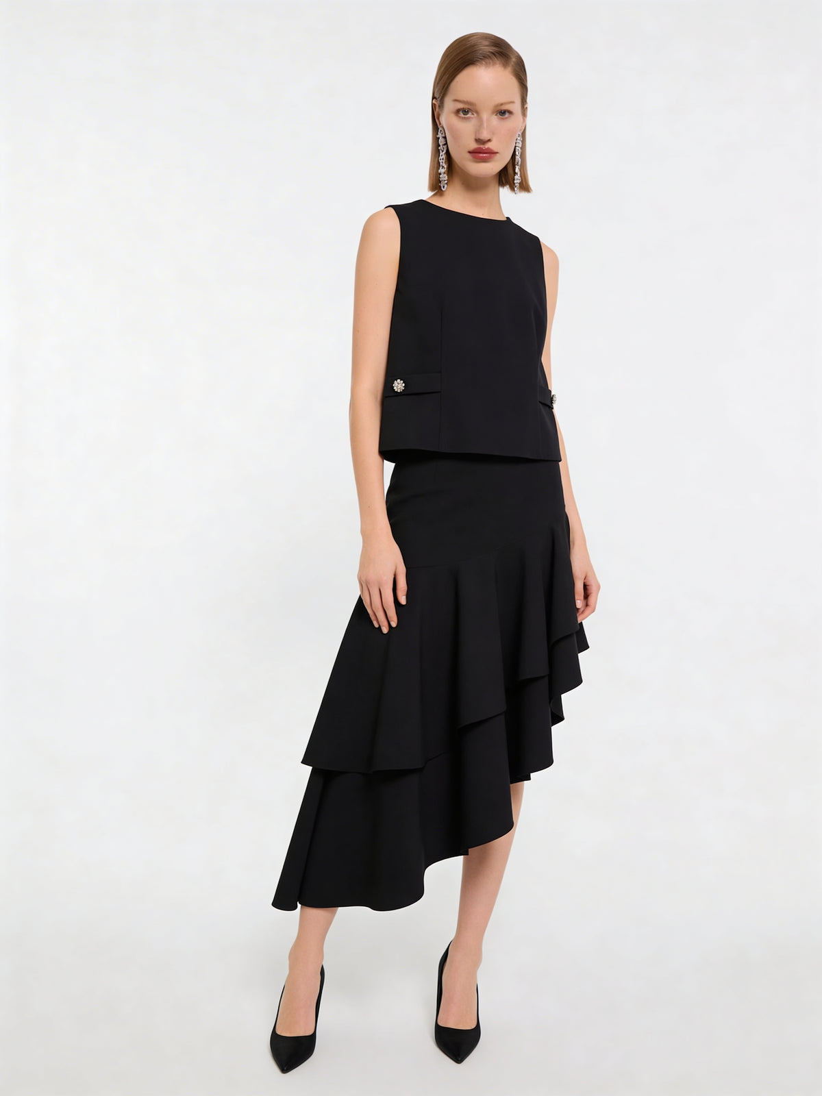 Model trägt schwarzen Wollrock mit hoher Taille und asymmetrischem Volantsaum