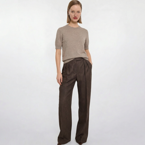 Model trägt elegante braune Wollhose mit Bundfalten und Wide-Leg-Schnitt