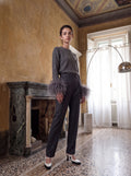Model trägt eleganten Merinowollpullover mit Federdetails von AELLE COLLECTIVE