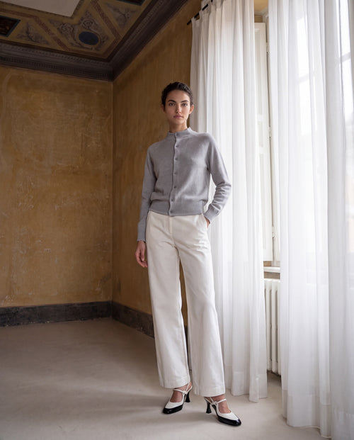 Model trägt roten Cashmere Cardigan mit weißer Stoffhose